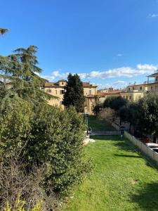 a park with trees and buildings in the background at L'Albero della Vita in Sinalunga