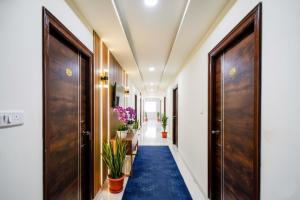 a hallway with wooden doors and a blue carpet at FabHotel Aashvi in Hyderabad