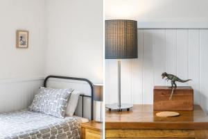 une chambre avec un lit et une statue de dinosaure sur une table dans l'établissement Coastal Retreat, à Kioloa