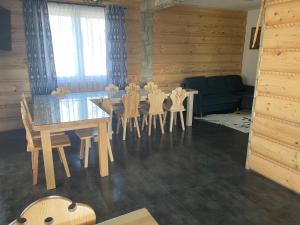 a dining room with a table and chairs and a couch at Domki przy szlaku Szczebel in Lubień +15 photos