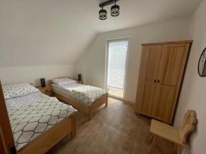 a bedroom with two beds and a window at Domki przy szlaku Szczebel in Lubień