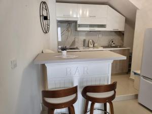 a kitchen with a bar with two chairs at it at Villa de Blue 3 in Bol