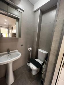 Un baño con lavabo, inodoro y espejo. en Beachside Studio Apartment with AC, en Costa de Adeje 6 fotos más