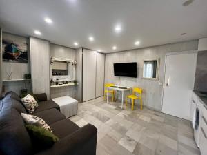 una sala de estar con un sofá y una mesa en Beachside Studio Apartment with AC, en Costa de Adeje