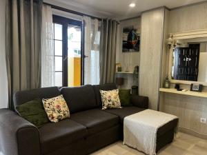 Una sala de estar con un sofá y una ventana. en Beachside Studio Apartment with AC, en Costa de Adeje