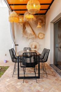 einen Esstisch mit Stühlen und Kronleuchtern in der Unterkunft Villa Marrakech réservée aux familles in Marrakesch