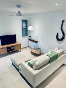 a living room with a couch and a flat screen tv at Nanua Lodge 1 green in Bora Bora