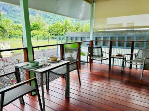 a porch with tables and chairs on a balcony at Nanua Lodge 1 green in Bora Bora
