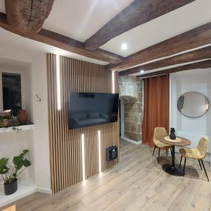 ein Wohnzimmer mit einem Fernseher an der Wand in der Unterkunft Le contemporain Centre historique in Langres