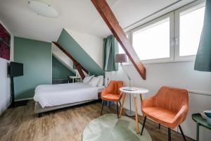 een hotelkamer met een bed en twee stoelen bij BergOpwaerts in Sint Odiliënberg