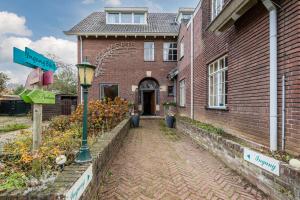 een stenen huis met een straatbord ervoor bij BergOpwaerts in Sint Odiliënberg