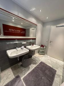 une salle de bain avec deux lavabos et un grand miroir dans l'établissement Baden-Chalet, à Brombach 26 autres photos