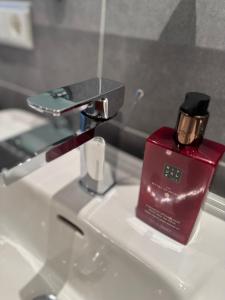 un distributeur de savon rouge posé sur un évier dans l'établissement Baden-Chalet, à Brombach