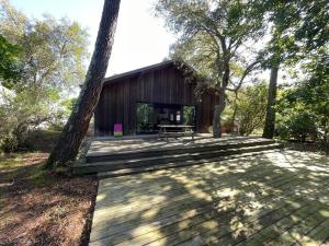a wooden deck in front of a wooden cabin at Villa 8 pers. Soustons proche lac, océan et golf, WiFi, animaux admis, parking - FR-1-379-83 in Soustons
