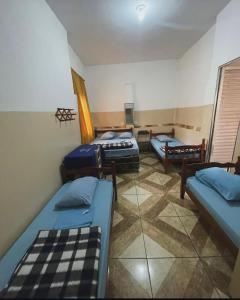 um quarto com três camas em um quarto em Santo Antônio do Mineiro em Aparecida