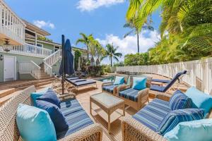 Hyatt Regency Maui Hotel HeliportHale Vista · VISTA Tropical Getaway at Kaanapali House to Relax的一个带柳条椅和遮阳伞的庭院