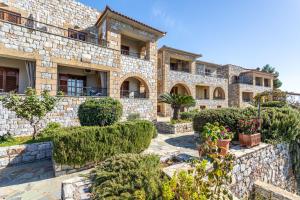 an exterior view of a stone building with plants at Vardia Hotel in Kardamili