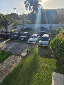 un groupe de voitures garées sur un parking avec un arc-en-ciel dans l'établissement Vila das Marés Beach Hotel, à São Sebastião