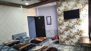 a room with a bed and a tv on a wall at Modern Guest House in Ujjain