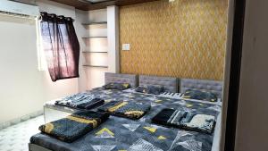 a bedroom with a bed with a blue and yellow comforter at Modern Guest House in Ujjain