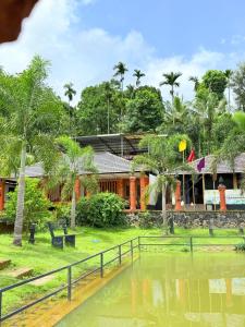 ein Haus mit einem Teich davor in der Unterkunft Rendezvous Jungle Resort in Sultan Bathery