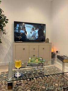 a living room with a tv and a table with a wine glass at Beautiful One Bed Studio Flat - Dog Friendly in Bridgwater