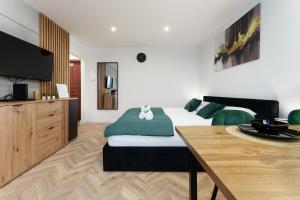 a bedroom with a bed and a television and a table at Modern Home in Sosnowiec