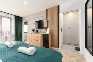 a bedroom with a green bed with towels on it at Modern Home in Sosnowiec