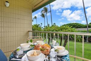una mesa con tazones y platos de comida en el balcón en Napili Shores F246 · NS F246 Spacious Condo w Pools AC Near Napi, en Kahana