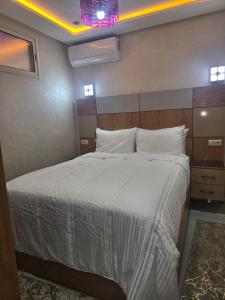 a bedroom with a bed with a white comforter at APPARTEMENT AMJAD iFRANE in Ifrane