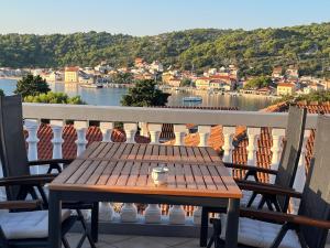 a wooden table on a balcony with a view of the water at Kate's Home Tisno in Tisno
