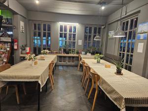 a dining room with tables and chairs and windows at Mandalar Arch 39 Hotel in Chiang Mai