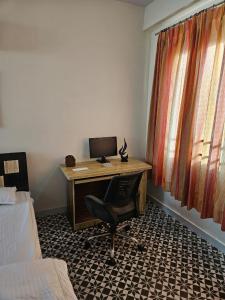 una scrivania con un computer e una sedia in una stanza di The Paavilion a Jaipur