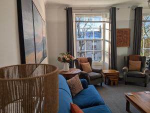 un salon avec un canapé bleu et des chaises dans l'établissement Eastgate Lodge Flat 23A, à Pickering