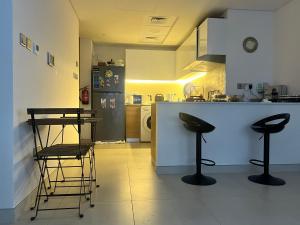 a kitchen with two bar stools and a counter top at Cozy Room In Abu Dhabi Reem island Near to Galeria Mall in Abu Dhabi