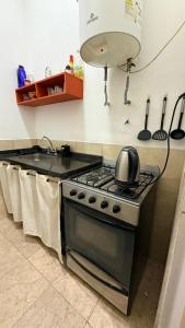 a kitchen with a stove with a tea kettle on it at Apart Granadero in Santiago del Estero