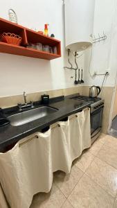 a kitchen with a sink and a stove with towels at Apart Granadero in Santiago del Estero