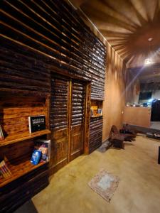 Una sala de estar con paredes de madera y un sofá. en Cinnamon Grove, en Udawalawe