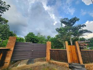 una valla con una puerta de madera y una valla en Cinnamon Grove, en Udawalawe