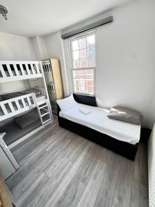 une chambre avec deux lits superposés et une fenêtre dans l'établissement London Duo & Quad Rooms in Zone 2 - Willesden Green, à Londres