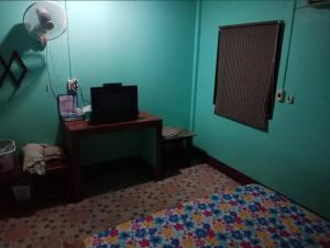 a bedroom with a bed and a television on a table at Saran Resort room 9 in Ban Khok Wat