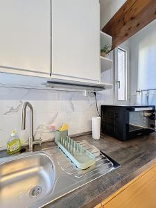 - un évier de cuisine avec un étendoir à vaisselle dans l'établissement Rue Bien Assis avec jardin terrasse, à Clermont-Ferrand