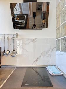 - une cuisine avec un comptoir, un évier et un miroir dans l'établissement Rue Bien Assis avec jardin terrasse, à Clermont-Ferrand 2 autres photos