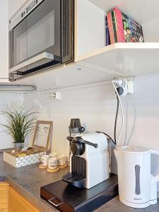 - un comptoir de cuisine avec une cafetière et un four micro-ondes dans l'établissement Rue Bien Assis avec jardin terrasse, à Clermont-Ferrand