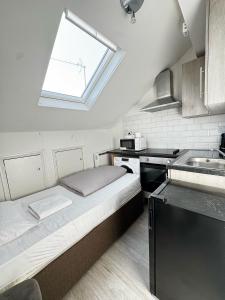 une petite cuisine avec un lit et une fenêtre dans l'établissement London Duo & Quad Rooms in Zone 2 - Willesden Green, à Londres 24 autres photos