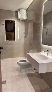 a bathroom with a toilet and a sink and a mirror at شقة البدر in Medina