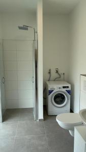 une salle de bains avec lave-linge et toilettes dans l'établissement Frisch saniert, Moderne Ferienwohnungen für 1 bis 37 Personen, Warme Weihnachten, à Böbingen an der Rems