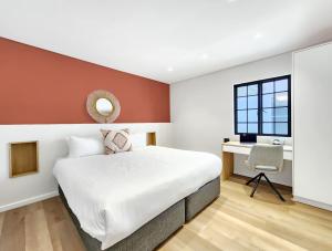 a bedroom with a large bed and a desk at Palm Paradise - Boutique Guest House in Cape Town