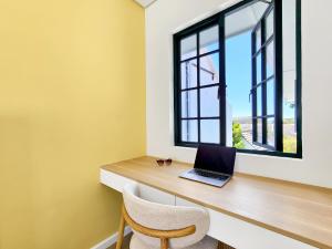 a laptop sitting on a desk in a room with a window at Palm Paradise - Boutique Guest House in Cape Town