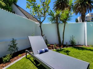 a bench with a paper on it sitting in a yard at Palm Paradise - Boutique Guest House in Cape Town